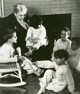 Jane Addams at Hull-House in front of fireplace with children. Courtesy of
the University of Illinois at Chicago