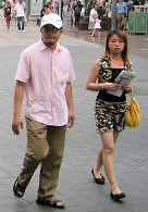 Photo of a well dressed Chinese couple in their 20's walking in a shopping district of Shanghai, China