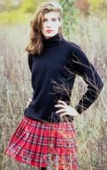 photo of a woman wearing a pleated skirt with a Scottish tartan plaid fabric pattern