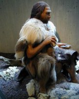 photo of a diorama showing a Neandertal man using percussion flaking to shape a Mousterian hand ax
