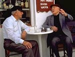 photo of two Greek men talking with each other at a coffee house