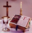 photo of a chalice, cross, candle, and Bible
