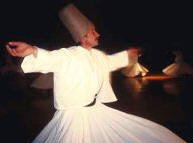 photo of a group of Turkish Dervishes with long flowing white skirts and jackets dancing in a circle